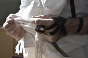 Sephardic Jew prays in synagogue with tefillin and tallit